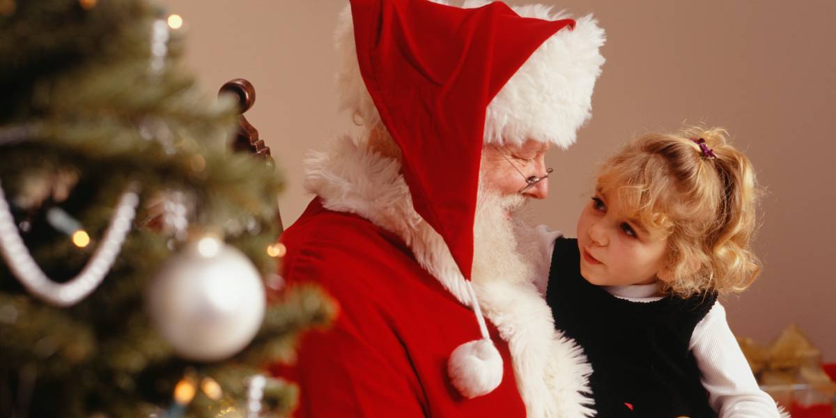 A young girl sitting with Santa